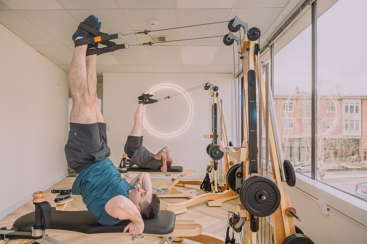 Man exercising with resistance bands in a home gym.
